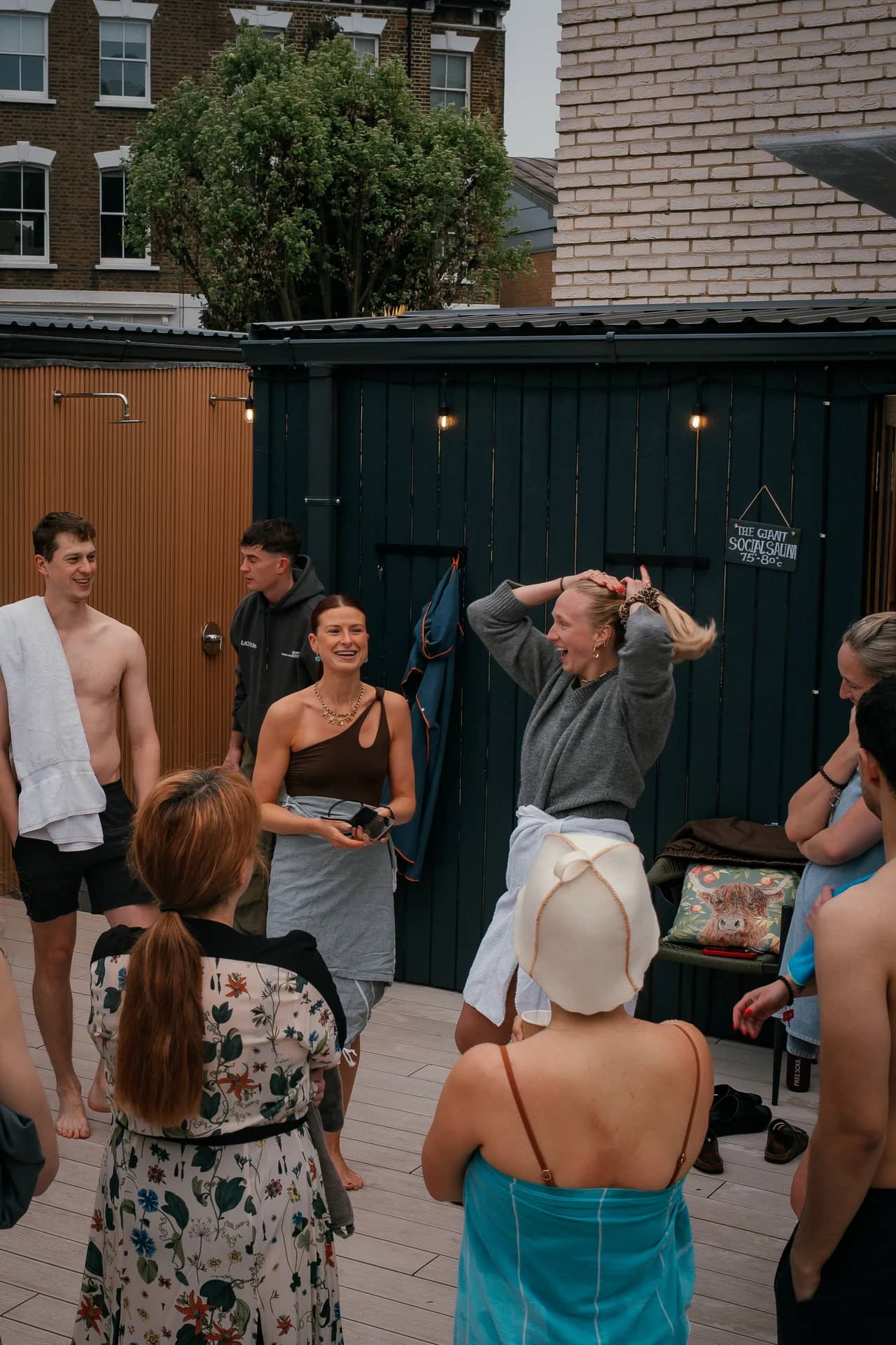 Guests gathering by the social sauna at Lowlu
